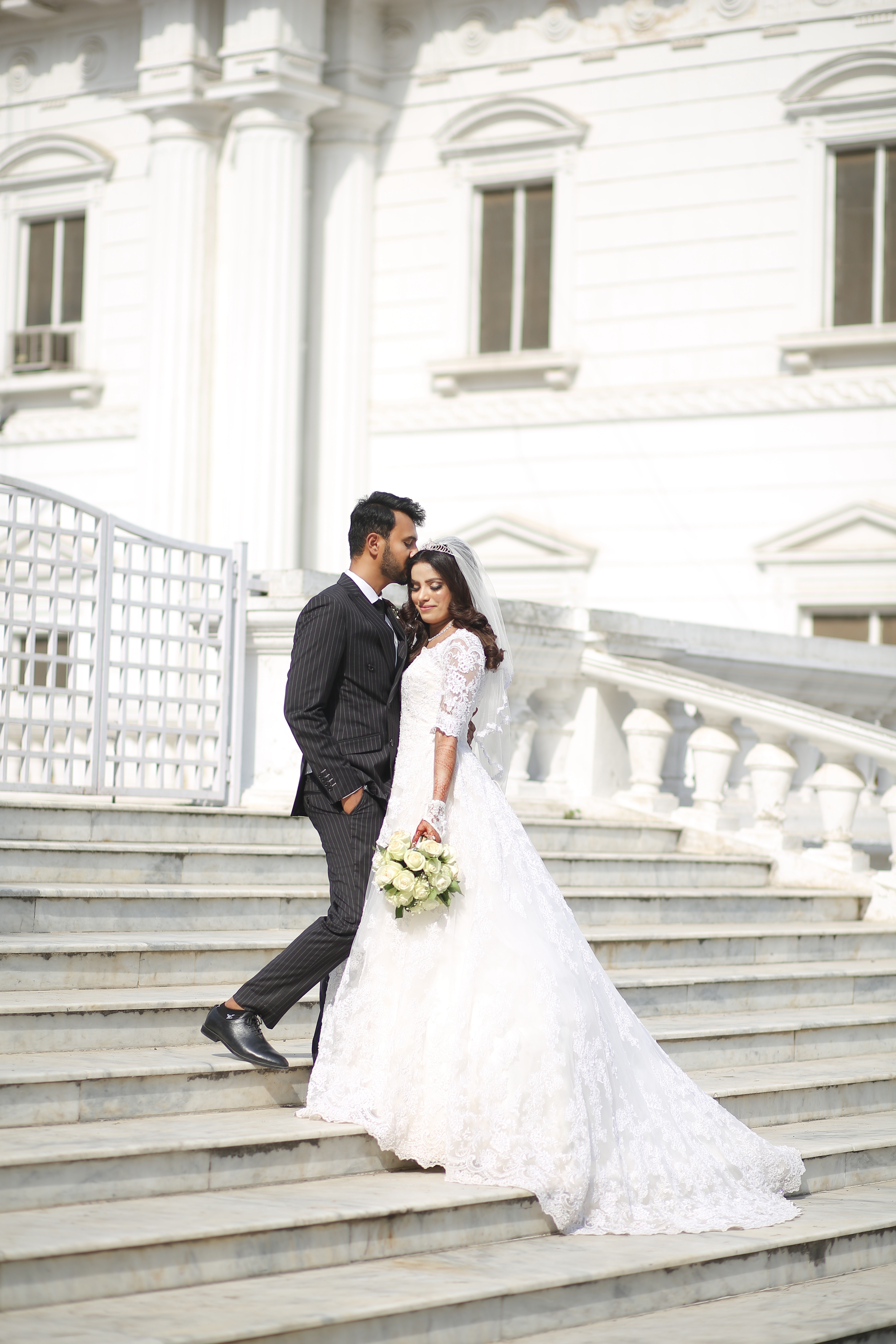 Elegant bride and groom wedding photoshoot on grand staircase captured by AM Productions wedding photographers in Pakistan